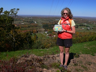 Zhanna displays the cache against a colorful panoramic backdrop.