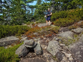 Rich pauses by a large cairn indicating the correct way.