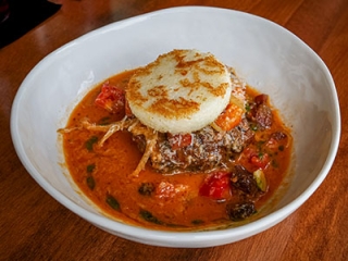 Slow-cooked pork with tomato cream, guanciale, parmesan, and grilled polenta