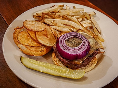 Venison burger with applesauce, onion, cheddar cheese, and fries