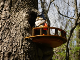 Another gnome looks on from a high perch.